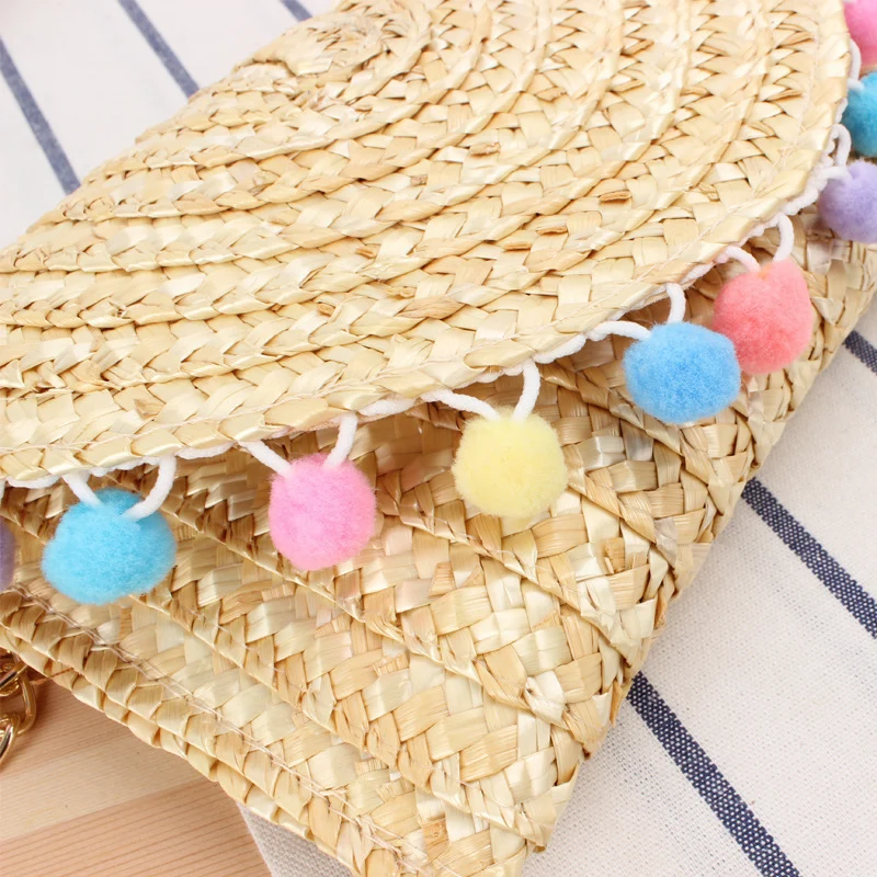 Handgewebte Clutch aus Naturmaterial mit dekorativen Pompons Skanto